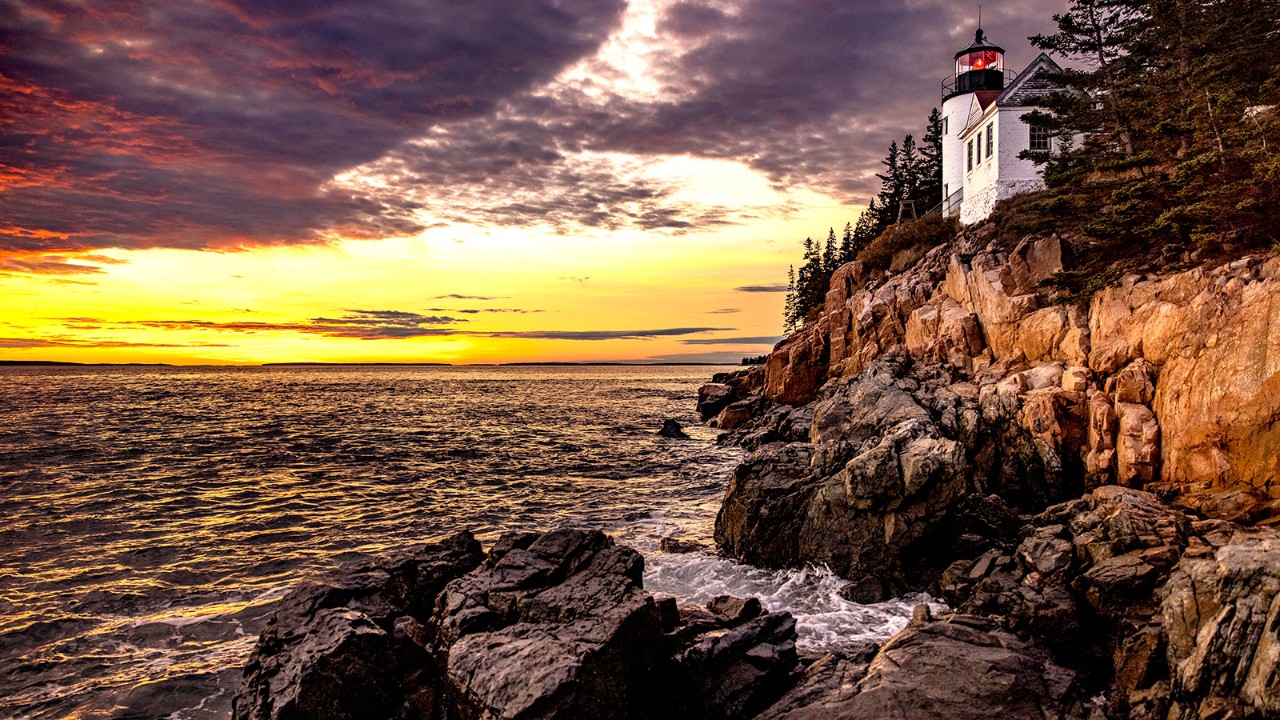 The sun sets behind the Bass Harbor Head Lighthouse in Acadia National Park.